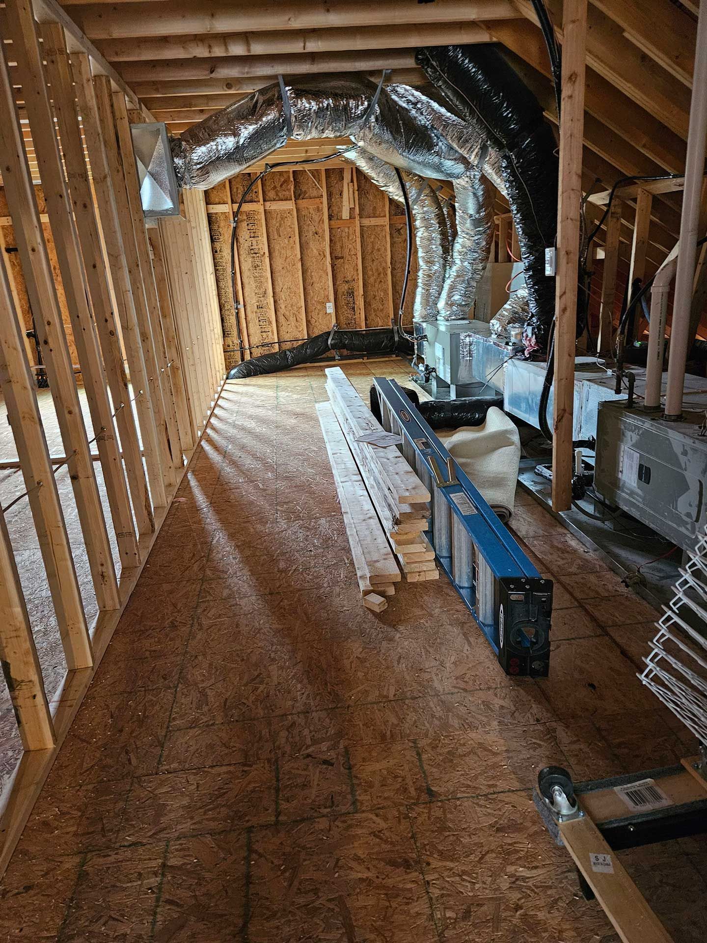 A ladder is sitting in the attic of a house under construction.