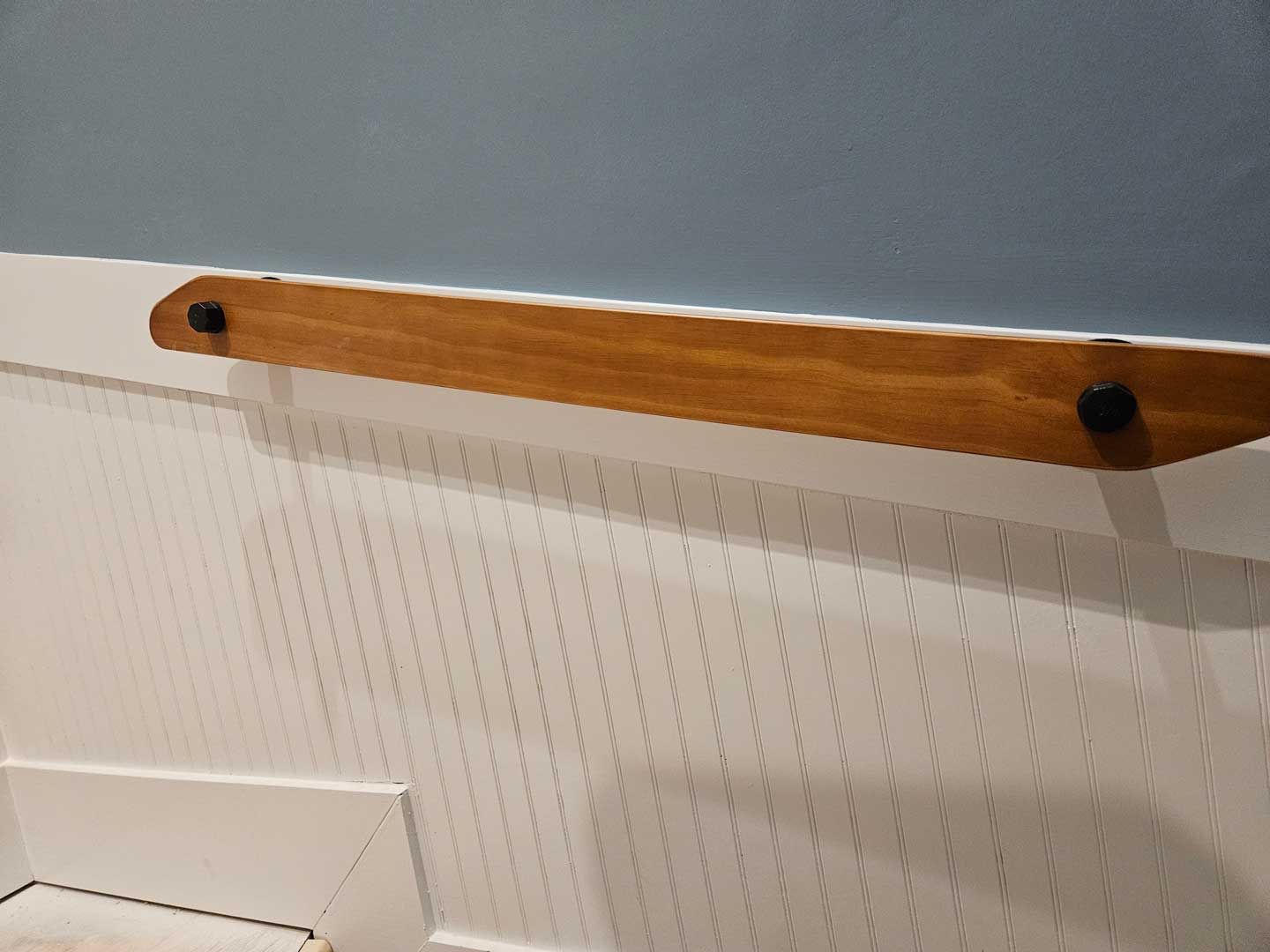 A white wall with a wooden handle on it