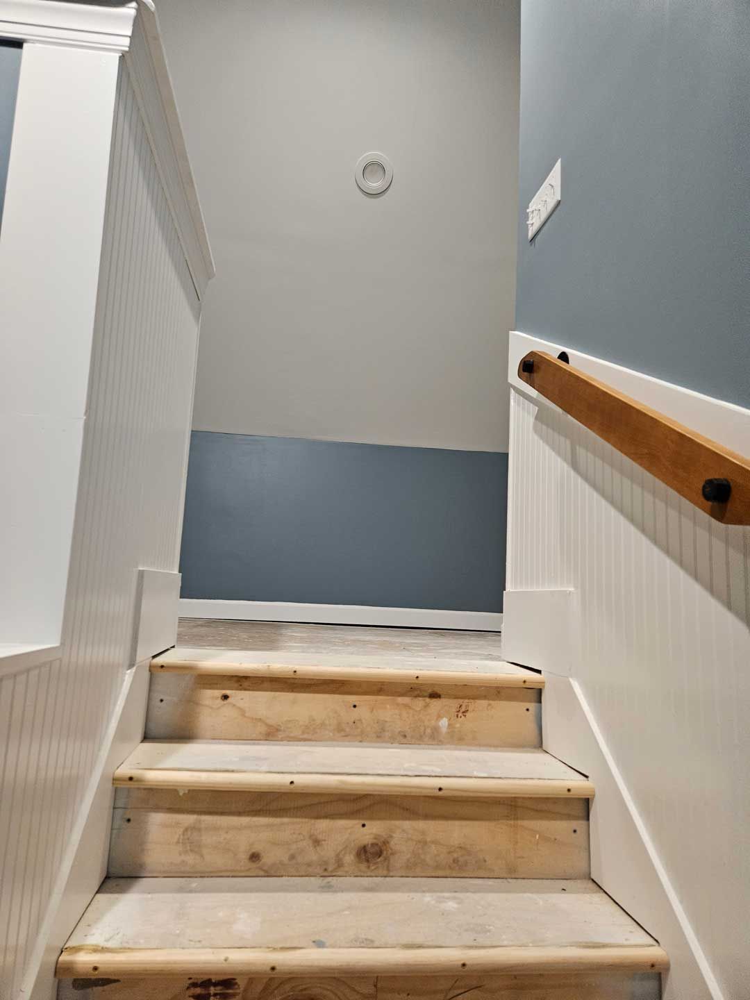 A set of wooden stairs leading up to the second floor of a house.