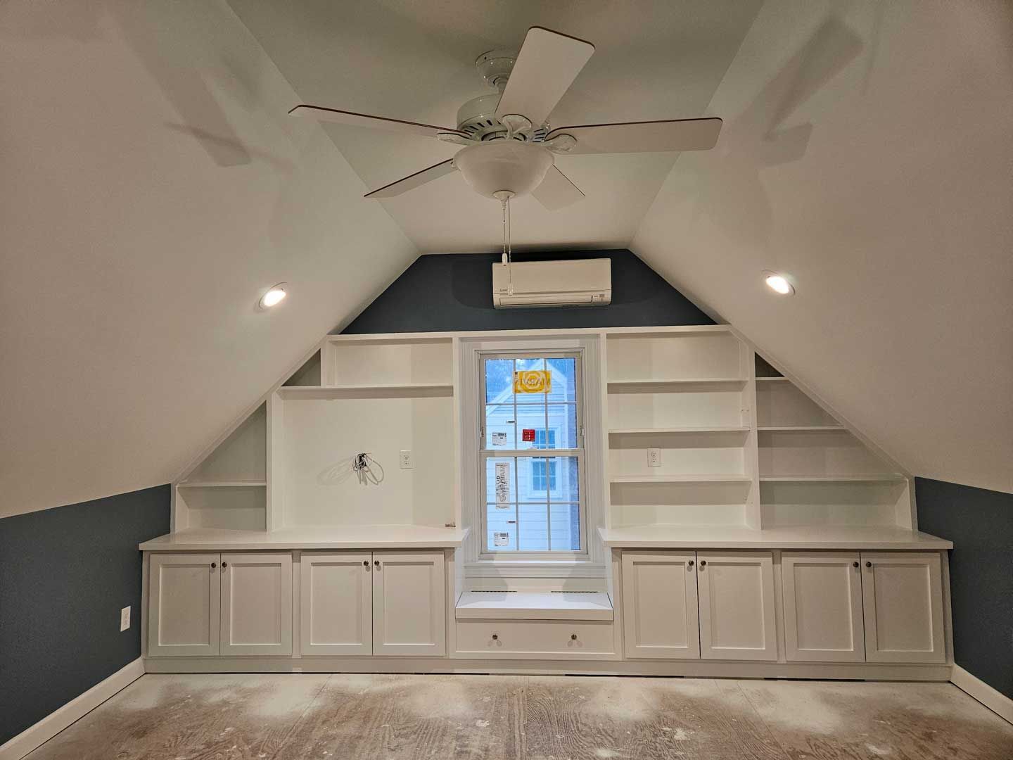 A room with a ceiling fan and a window