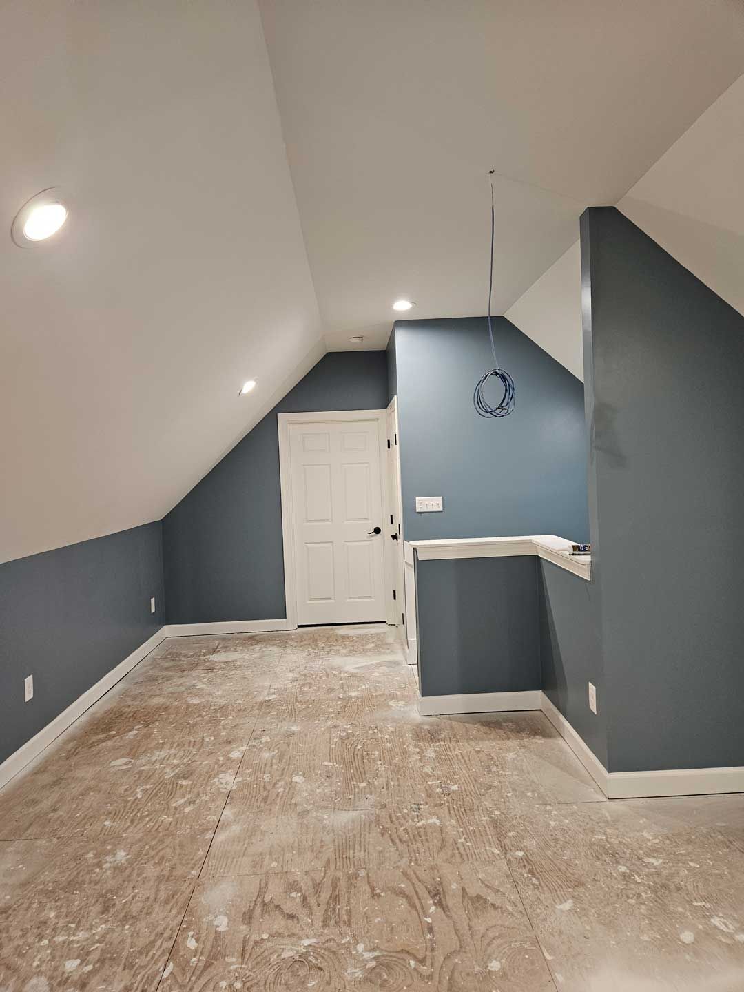 An empty room with blue walls and a white door.