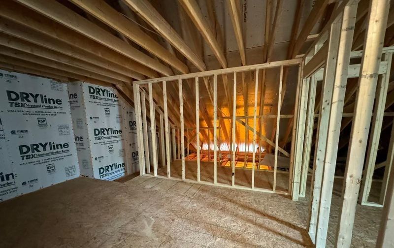 A room in a house under construction with wooden beams.