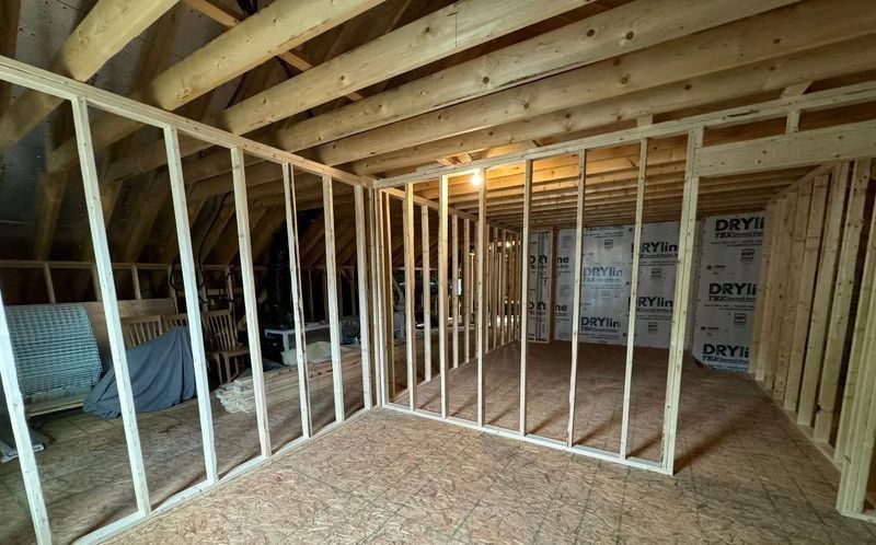 A room under construction with wooden walls and a ceiling.