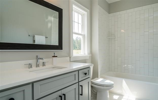 A bathroom with a sink , toilet , tub and mirror.