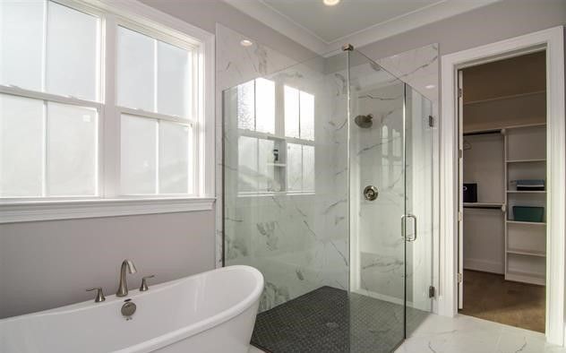 A bathroom with a tub and a walk in shower.