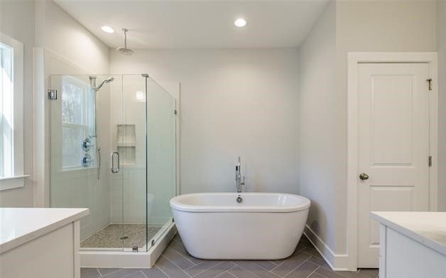 A bathroom with a bathtub and a walk in shower.