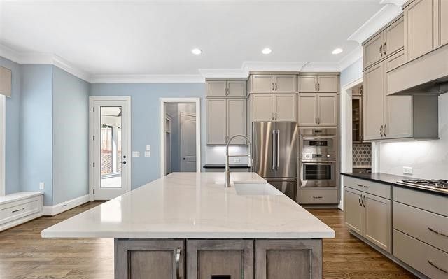 A kitchen with a large island and stainless steel appliances.