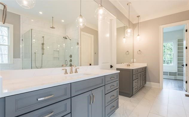 A bathroom with two sinks and a walk in shower.