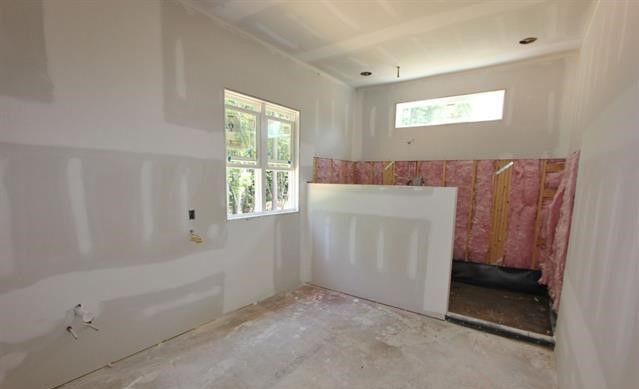 A bathroom under construction with a bathtub and a window.