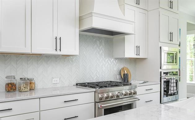 A kitchen with white cabinets and stainless steel appliances.