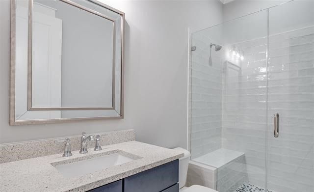 A bathroom with a sink , toilet , shower and mirror.