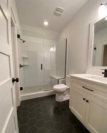 A bathroom with a toilet , sink , shower and mirror.