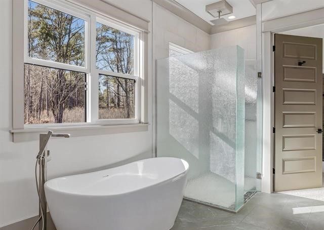 A bathroom with a bathtub and a walk in shower.