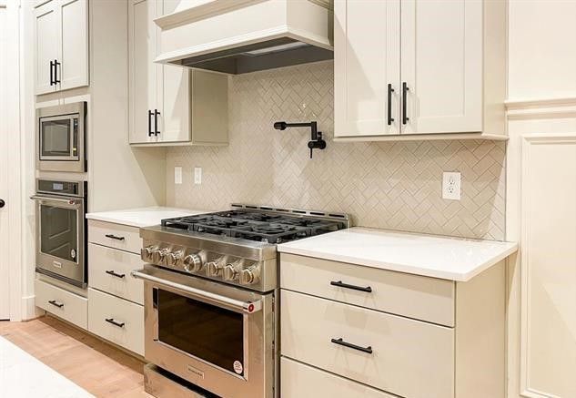 A kitchen with stainless steel appliances and white cabinets.