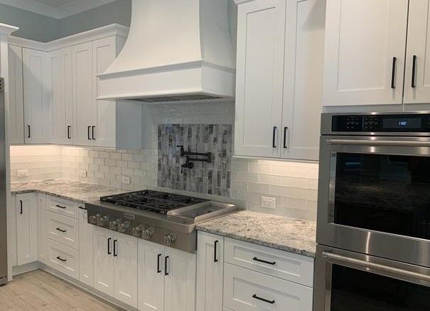 A kitchen with white cabinets and stainless steel appliances.