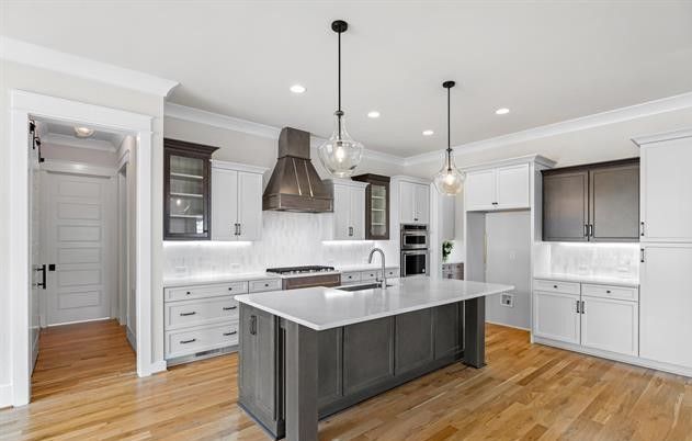 A kitchen with white cabinets and a large island in the middle.