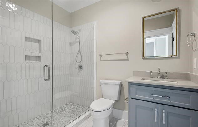 A bathroom with a toilet , sink , and walk in shower.