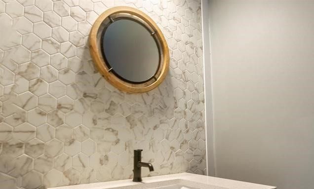 A bathroom with a sink and a mirror on the wall.