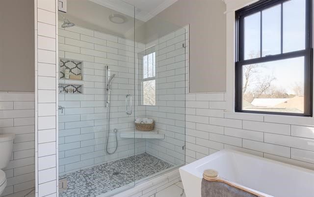 A bathroom with a walk in shower and a bathtub.