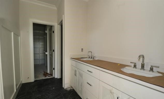 An empty bathroom with white cabinets and a sink