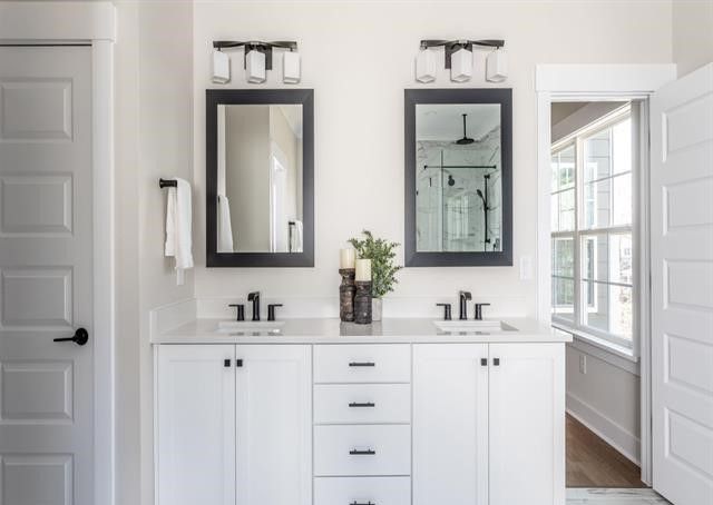 A bathroom with two sinks and two mirrors.