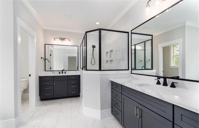 A bathroom with two sinks , two mirrors and a walk in shower.