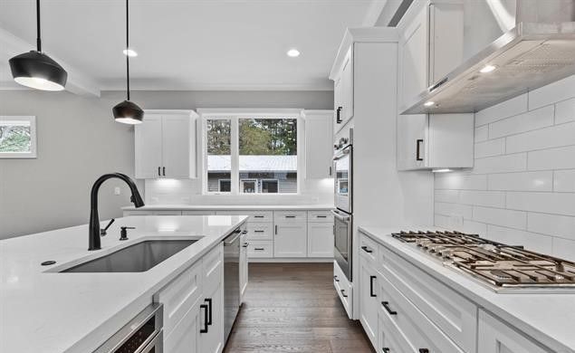 A kitchen with white cabinets and stainless steel appliances