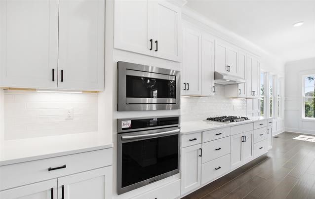 A kitchen with white cabinets and stainless steel appliances.