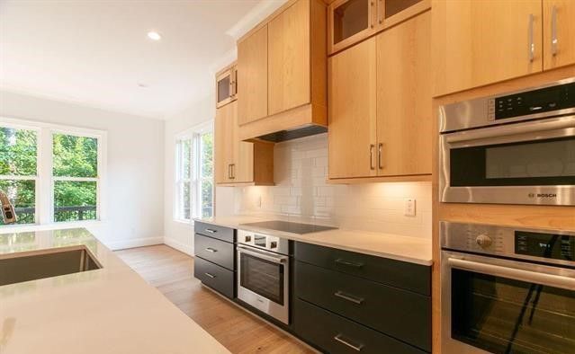 A kitchen with stainless steel appliances and wooden cabinets.