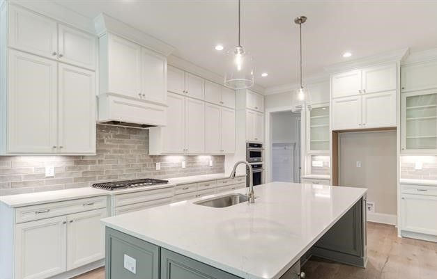 A kitchen with white cabinets and a large island in the middle.