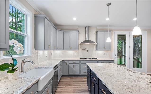 A kitchen with gray cabinets , granite counter tops , a sink and a stove.