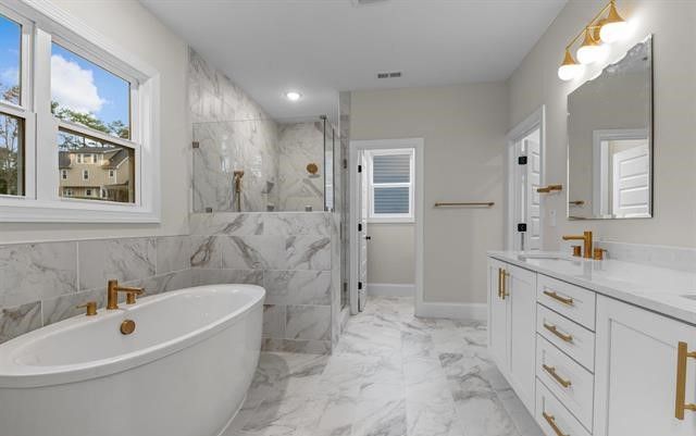 A bathroom with a tub , sink , mirror and window.