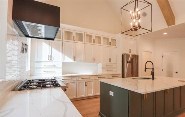 A kitchen with white cabinets , stainless steel appliances , and a large island.