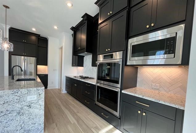 A kitchen with black cabinets and stainless steel appliances.