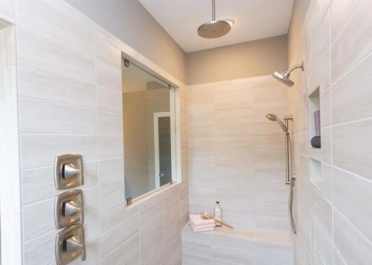A bathroom with a walk in shower and a window.