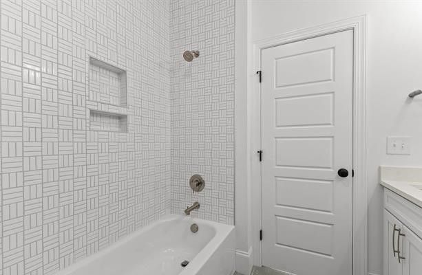 A bathroom with a bathtub , sink , and shower.