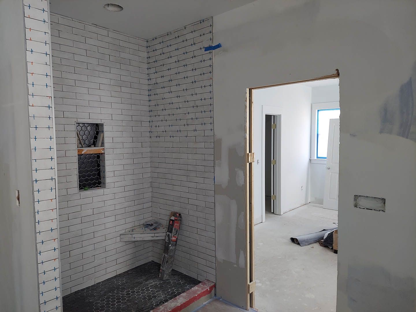 A bathroom under construction with a walk in shower.