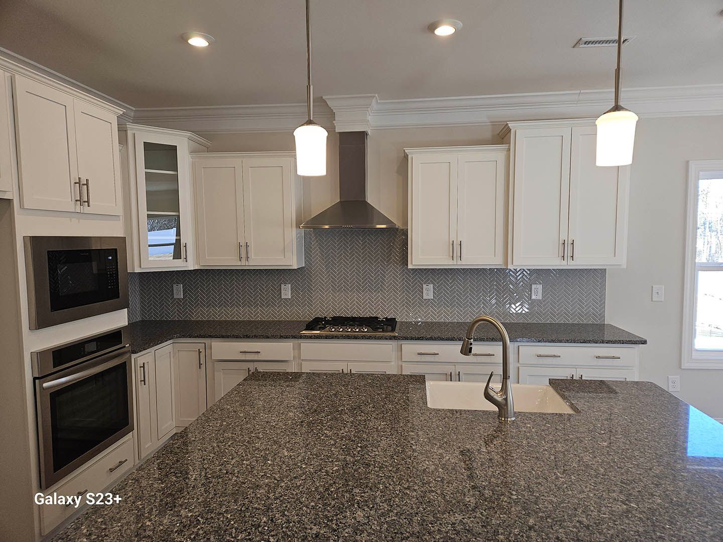 A kitchen with granite counter tops and white cabinets