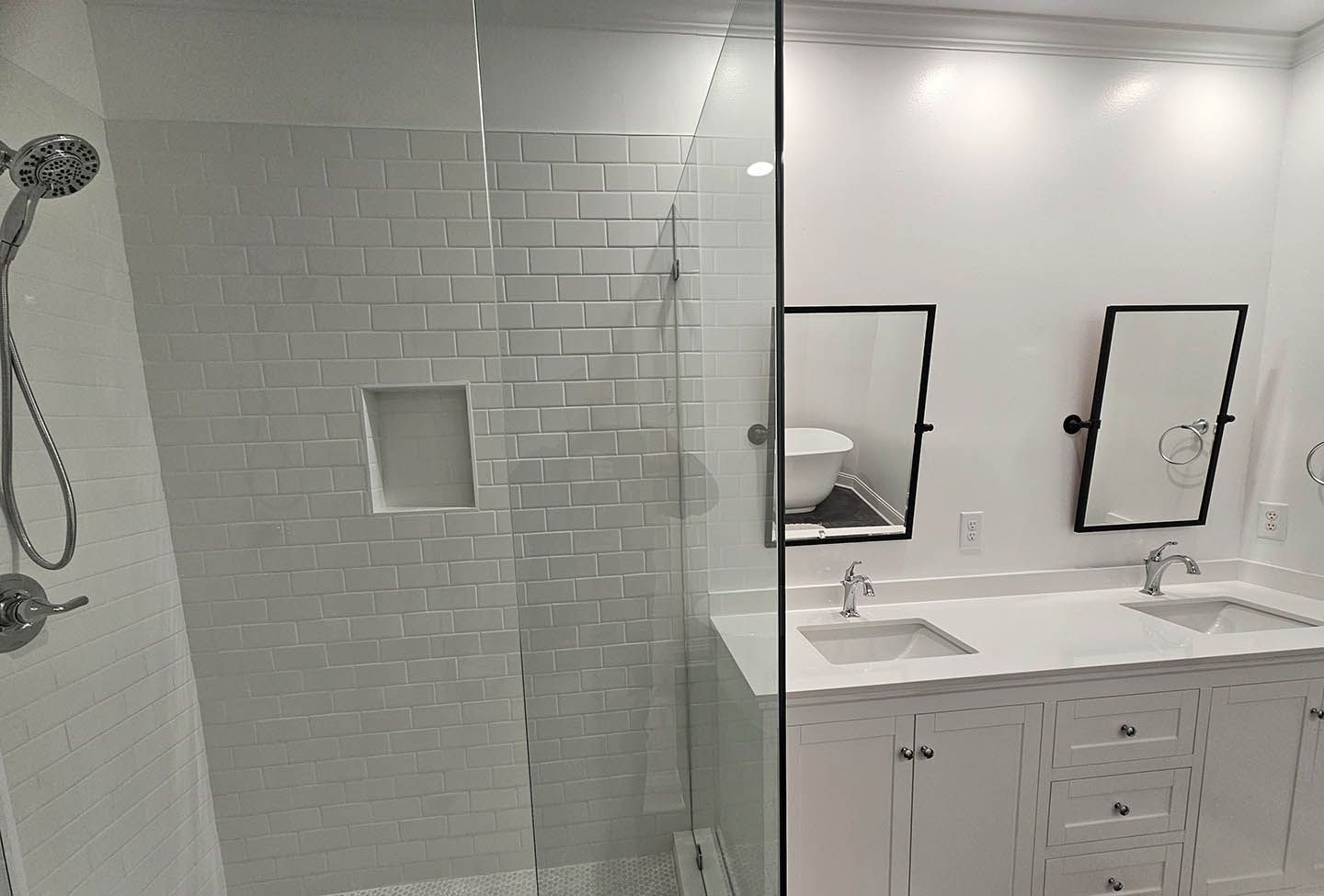 A bathroom with a walk in shower and two sinks.