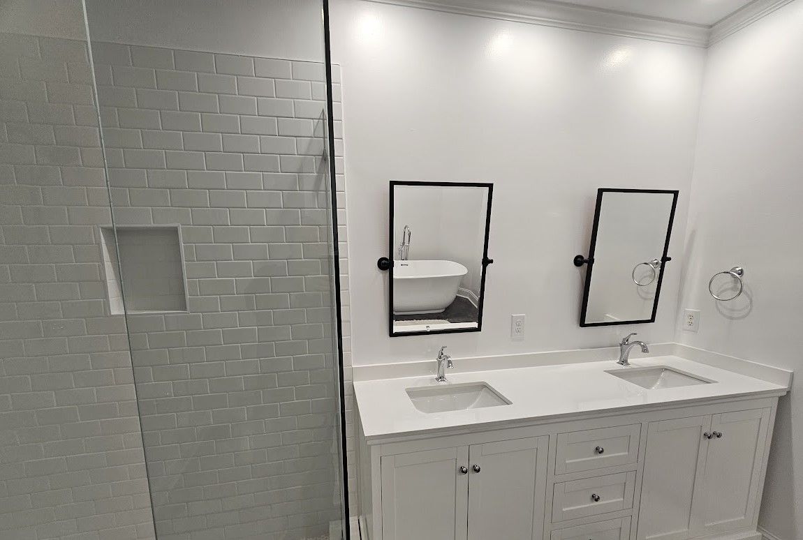 A bathroom with two sinks and a walk in shower.