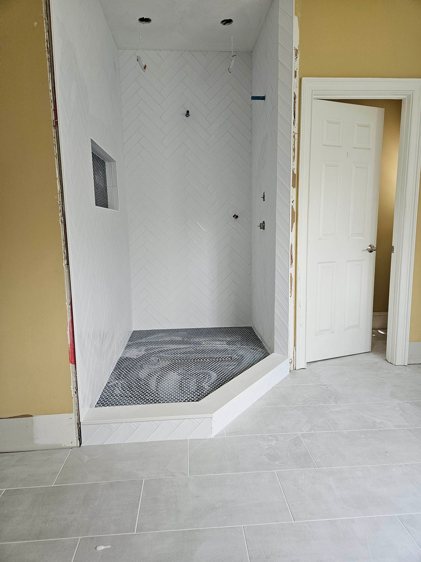 A bathroom with a walk in shower and a door.