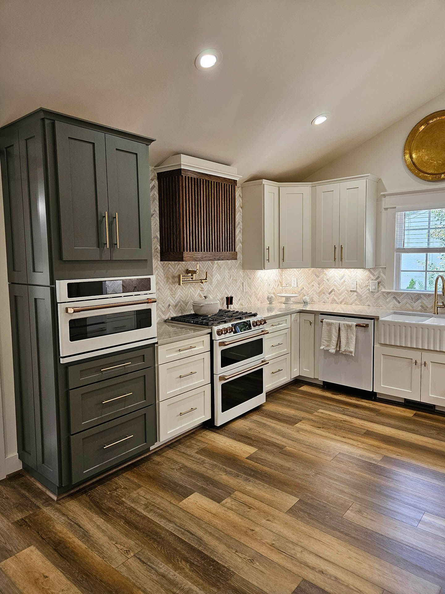 A kitchen with a stove , oven , sink and cabinets.