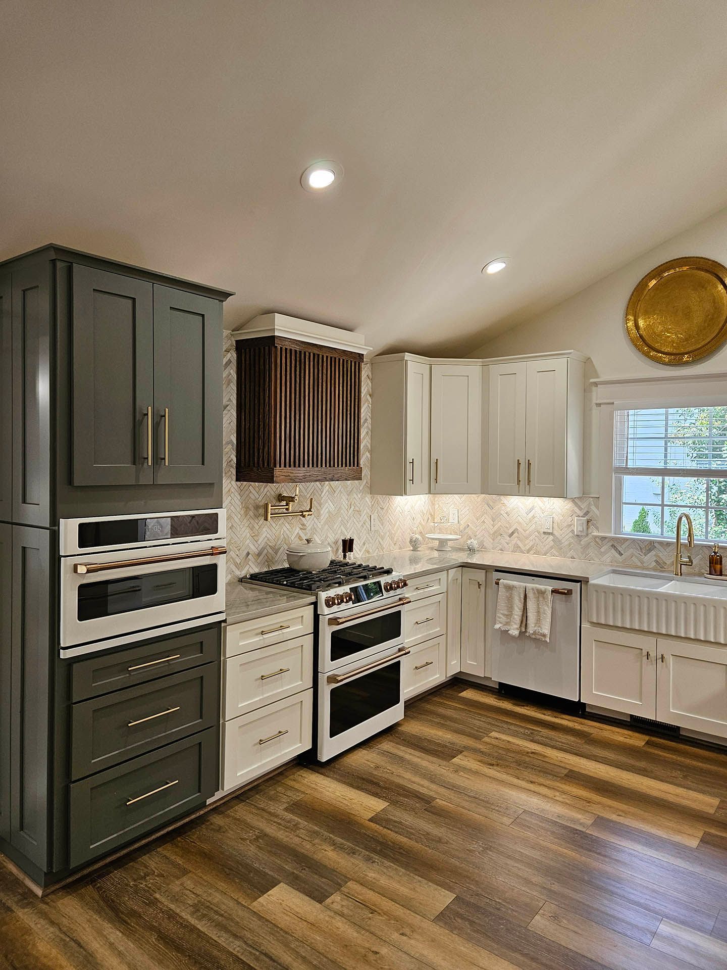 A kitchen with stainless steel appliances and wooden floors.