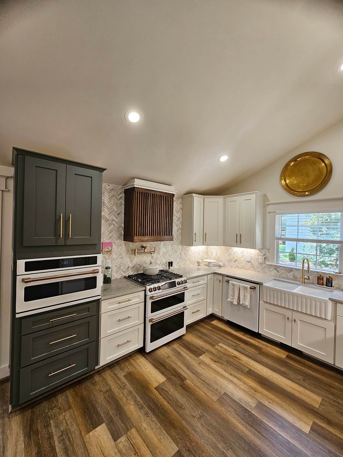 A kitchen with a stove , oven , sink , and cabinets.