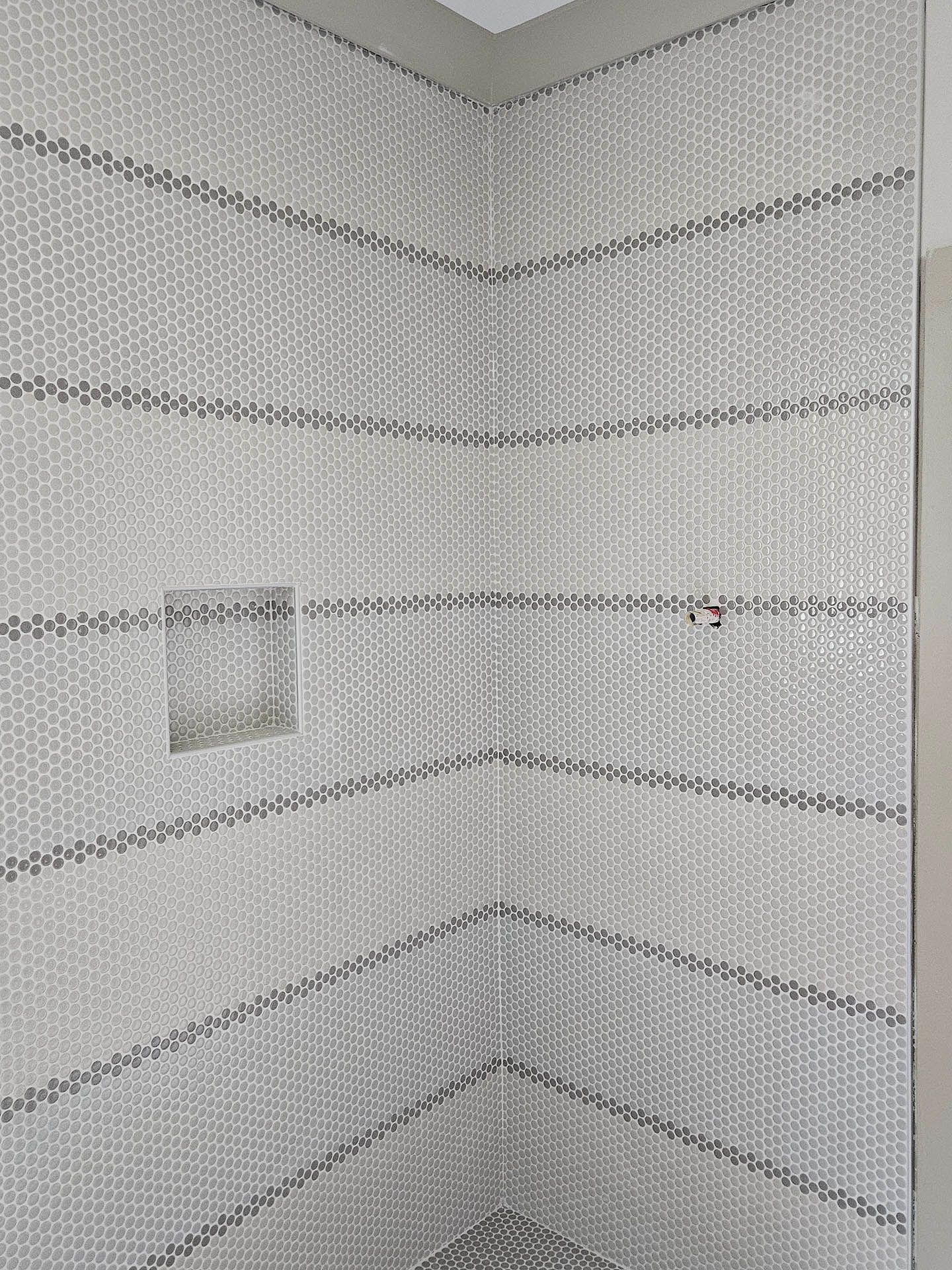 A bathroom with a shower stall and a shower head.