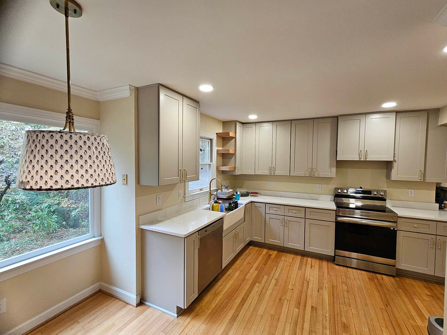 A kitchen with white cabinets , stainless steel appliances , and hardwood floors.