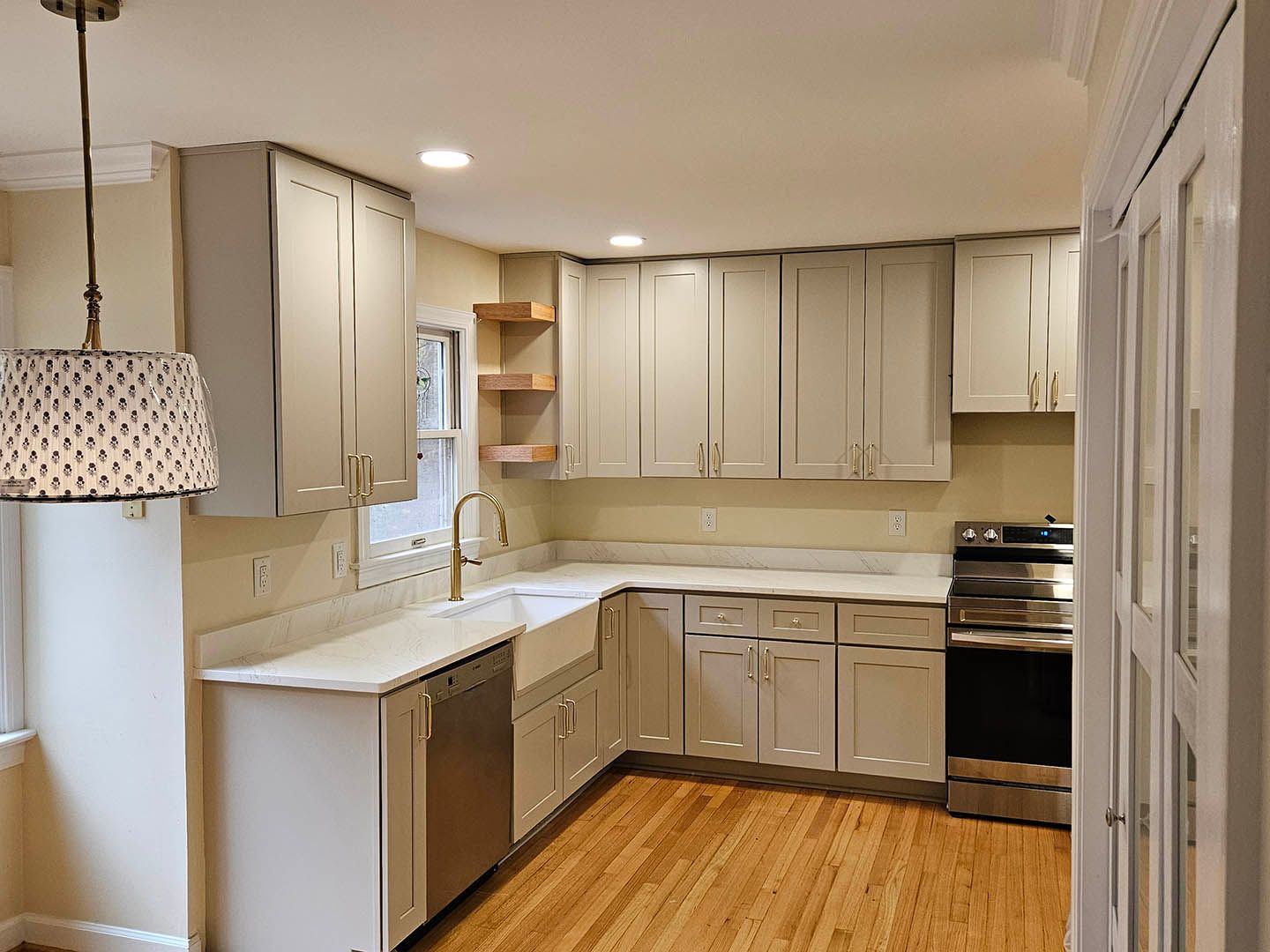 A kitchen with white cabinets and hardwood floors