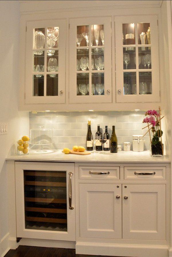 A kitchen with white cabinets and a wine cooler