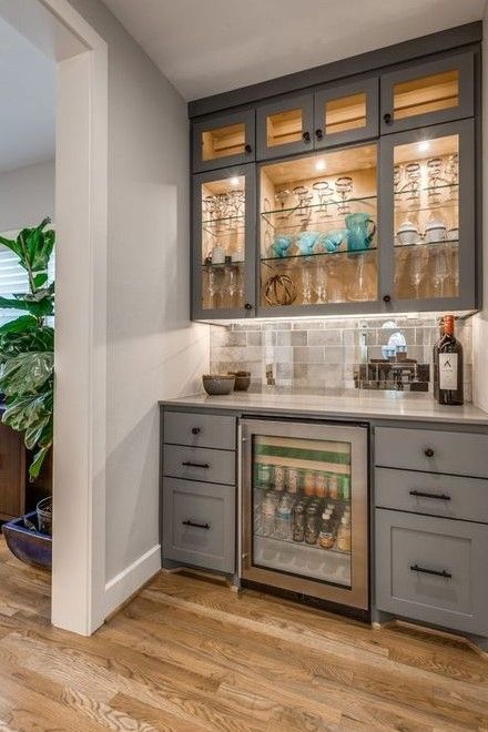 A kitchen with gray cabinets and a glass door refrigerator.
