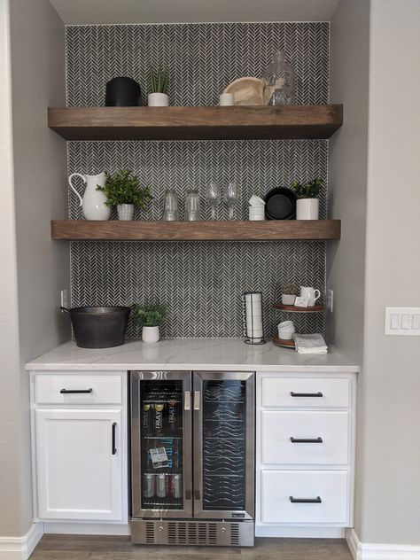 A kitchen with white cabinets and a stainless steel refrigerator.